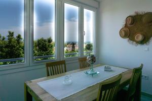 a dining room with a table and four windows at Sun & Luxury at Guadalmar Beach in Málaga