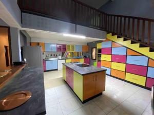 a large kitchen with colorful cabinets and a staircase at Résidences Gamly in Mamoudzou