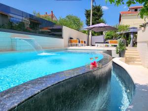 basen z fontanną i 2 kieliszkami do wina w obiekcie Calypso Royal Apartment w mieście Zadar