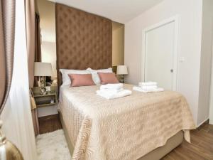 sypialnia z dużym łóżkiem z dwoma ręcznikami w obiekcie Calypso Royal Apartment w mieście Zadar