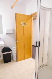 a bathroom with a wooden door in a bathroom at Delta Lodge in Delta Junction