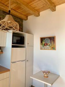 eine Küche mit einem weißen Kühlschrank und einem Tisch in der Unterkunft ΠΕΤΡΙΝΟ στην Άνδρο in Agia Eleousa