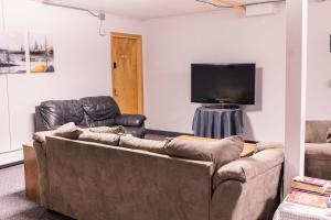 a living room with two couches and a flat screen tv at Delta Lodge in Delta Junction