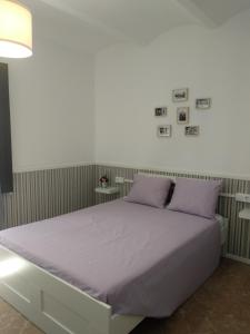 1 dormitorio con 1 cama grande con almohadas moradas en Can Silvestre, en Besalú