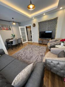 Il comprend un salon avec des canapés et une télévision à écran plat. dans l'établissement Fatih / Aksaray - Yusufpaşa, à Istanbul