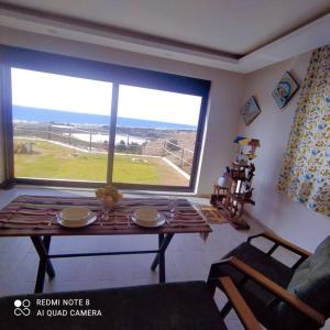 Delfina and Delfino Cozy Home في Kışlabucağı: غرفة معيشة مع طاولة ونافذة كبيرة