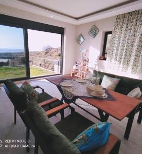 a living room with a table and a couch at Delfina and Delfino Cozy Home in Kışlabucağı