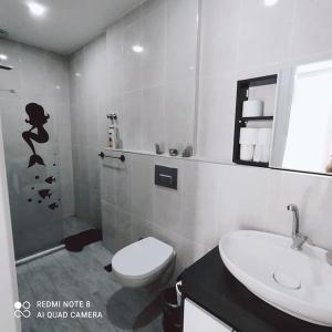 Baño blanco con aseo y lavamanos en Delfina and Delfino Cozy Home en Kışlabucağı