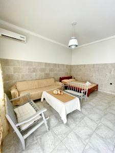 ein Wohnzimmer mit einem Sofa, einem Tisch und Stühlen in der Unterkunft Poseidonia's Breeze in Posidhonía
