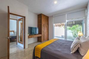 a bedroom with a bed and a tv and a window at Casa Quince - Monterosa in Sayulita +53 photos