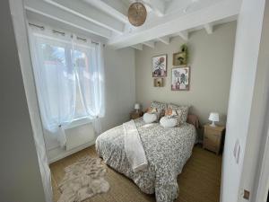 a bedroom with a bed and a window at la Casa d'Olianna - Jolie Maison / Jeux / Grand jardin in Villeny