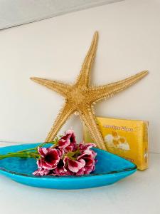 a blue plate with a starfish and flowers on it at Poseidonia's Breeze in Posidhonía