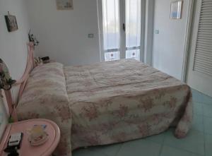 Bett in einem Zimmer mit einem Tisch und einer Tagesdecke in der Unterkunft CASA VACANZE 'LA BOUGANVILLEA' FORIO ISCHIA in Ischia