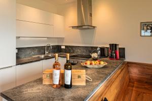 a kitchen with two bottles of wine on a counter at Weingut Eichenstein in Merano +5 photos