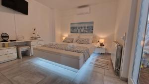Apartman Bela في نجيفيش: غرفة نوم بيضاء مع سرير كبير ومكتب