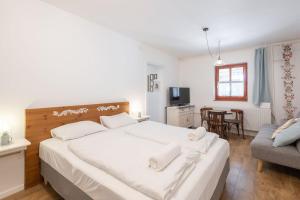 蒂豪尼Kékmadaras Vendégház Tihany的一间带一张白色大床的卧室和一间客厅