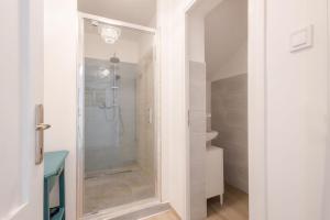 een badkamer met een douche en een glazen deur bij Kékmadaras Vendégház Tihany in Tihany