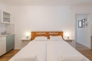 a bedroom with a large white bed with white sheets at Kékmadaras Vendégház Tihany in Tihany