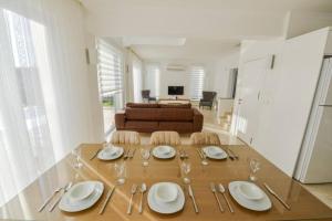 フェティエにあるVilla Marsel evi Ölüdeniz Fethiyeのダイニングルームテーブル(皿、グラス、ソファ付)