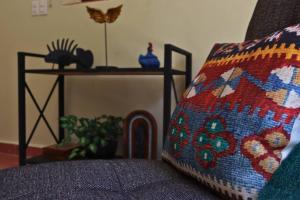a couch with a crochet pillow sitting next to a table at Casa Coco in Mérida