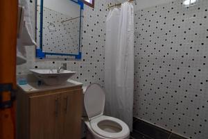 a bathroom with a white toilet and a sink at casa mirador honduras in Puerto Triunfo +14 photos