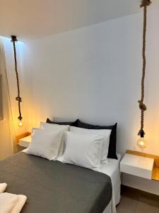 een slaapkamer met een bed met witte kussens bij Rodanthi 4 Seasons Unique House in Tympáki