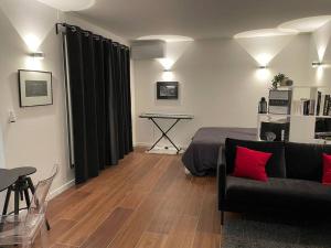 a living room with a couch and a table and a piano at The Prism ,studio on the top floor with a balcony in Neuilly-sur-Seine