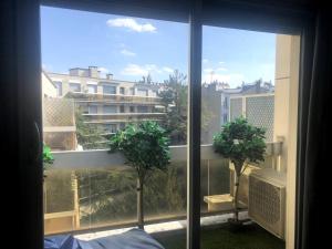 a room with a window with two trees in it at The Prism ,studio on the top floor with a balcony in Neuilly-sur-Seine