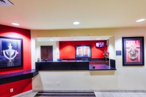 a large lobby with red walls and a counter at Homestyle Studio Suites in Annapolis