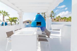 Villas Veaco Bahiazul with private pool في كوراليخو: غرفة طعام بيضاء مع منزل حرباء زرقاء