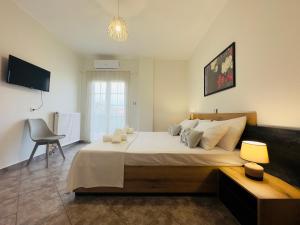 a bedroom with a large bed and a chair at Almyriki Apartment in Ierissos