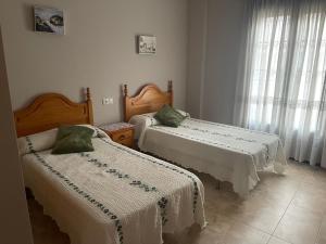 1 dormitorio con 2 camas con sábanas blancas y ventana en Casa Josefa, en Pozo Alcón