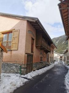 une maison avec de la neige sur le côté d'une rue dans l'établissement Gîte 14 pers LesOursFanfarons spacieux chaleureux, à Bramans