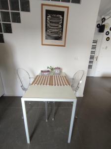 uma mesa branca com duas cadeiras num quarto em Casa Bonatti em Peschiera del Garda
