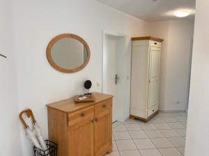 een badkamer met een spiegel en een houten dressoir bij Strandidyll in Zempin