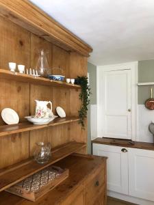 a kitchen with a wooden shelf with plates on it at Traditional Cottage in Harbour Town of Watchet in Watchet