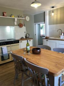 a kitchen with a wooden table with a bottle of wine on it at Traditional Cottage in Harbour Town of Watchet in Watchet