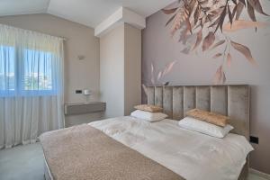 a bedroom with a large bed with a painting on the wall at Residence Franc in Primošten