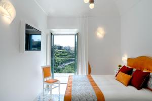 スカラにあるResidence Villa Ruoccoの白いベッドルーム(大型ベッド1台、窓付)