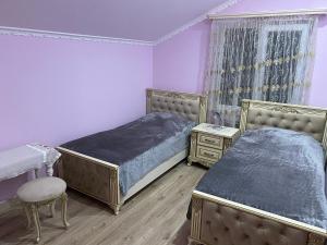 a bedroom with two beds and a table and a chair at Green House in Dilijan