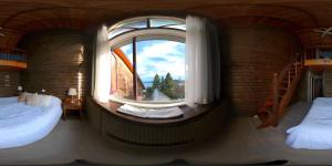 a room with two beds and a large window at Hosteria La Luna in San Carlos de Bariloche