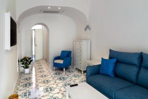 a living room with a blue couch and a chair at Residence Villa Ruocco in Scala