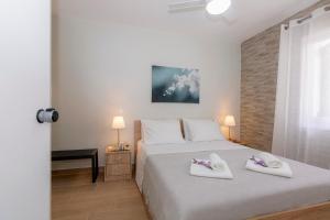 a bedroom with a bed with two white shoes on it at sofia's apart 4u (114) in Glyfada