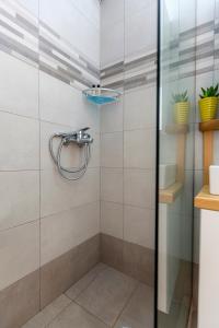 a shower with a glass door in a bathroom at sofia's apart 4u (114) in Glyfada