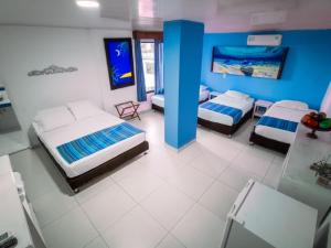 a bedroom with two beds and a blue wall at La Posada De Lulú in San Andrés