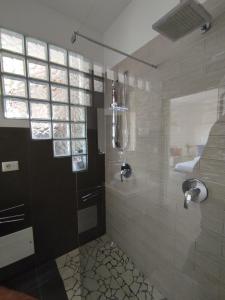 uma casa de banho com um chuveiro e uma porta de vidro em Casa Bonatti em Peschiera del Garda