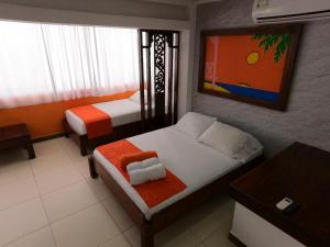 a small bedroom with two beds and a table at La Posada De Lulú in San Andrés