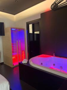 a large bathroom with a large tub with pink lighting at Maximum hub suite&spa in Palermo