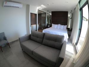 um quarto de hotel com uma cama e um sofá em Tropical Executive Hotel em Manaus