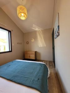 ein Schlafzimmer mit einem Bett mit einer blauen Decke in der Unterkunft Air marin in La Bernerie-en-Retz